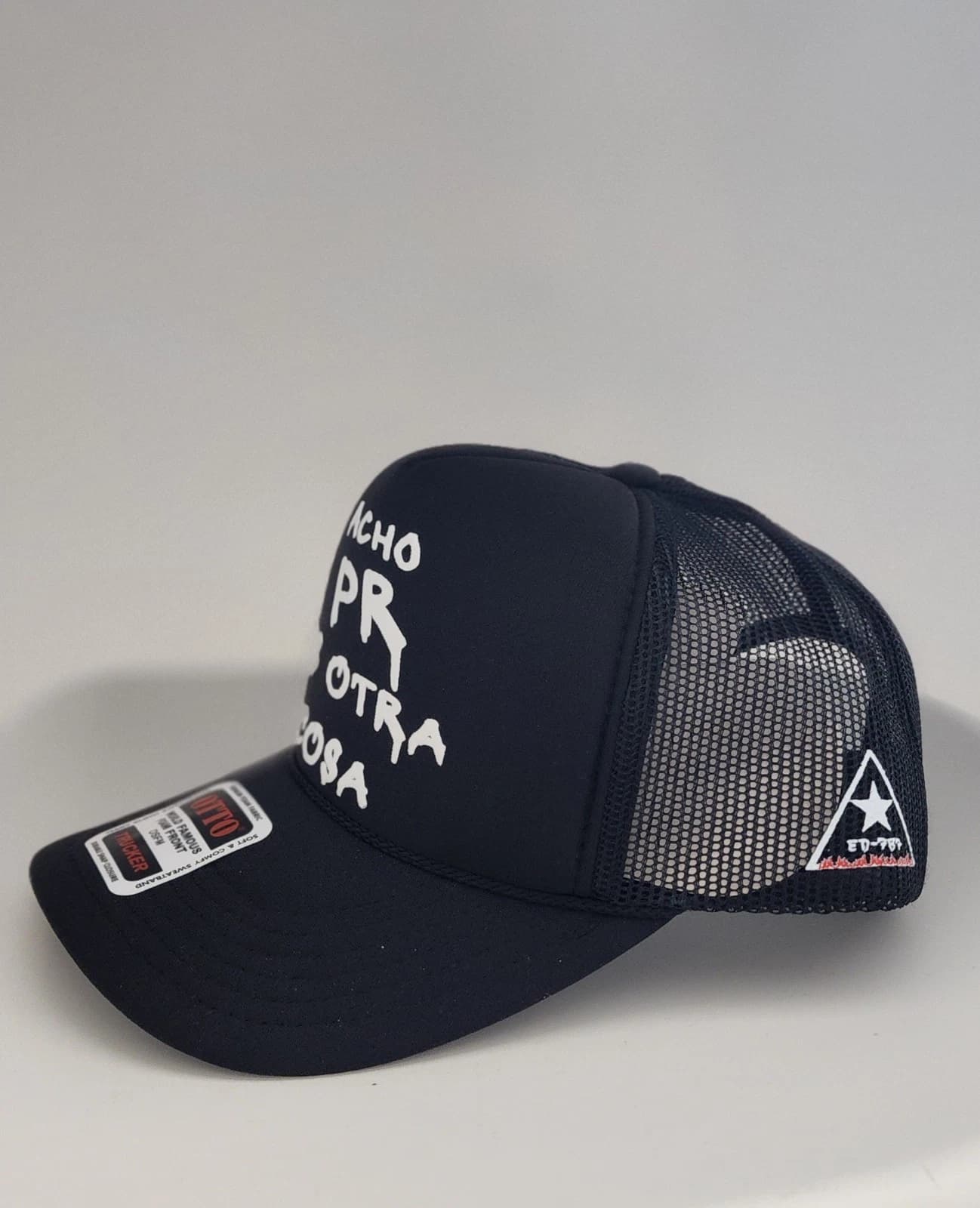 Vista 3/4 de la trucker ACHO PR mostrando el badge ED-787 en la malla